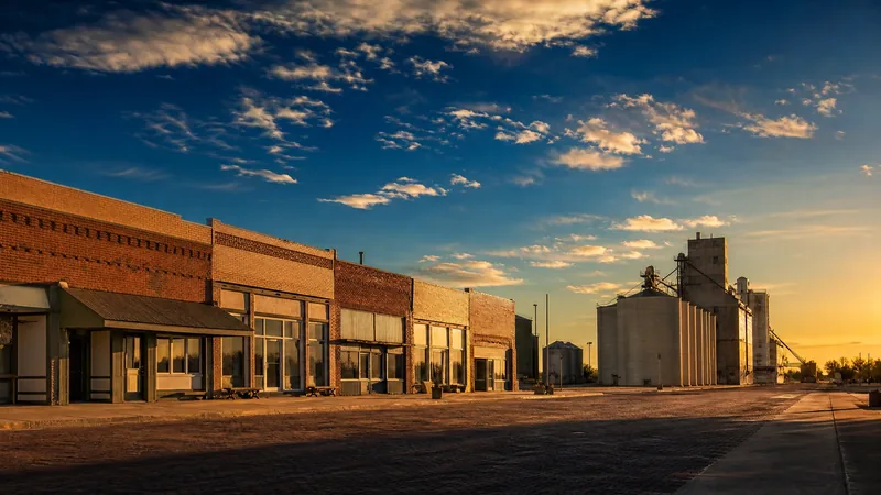 Small northern plains downtown of brick storefronts beside a grain elevator under a wide sky, Minot Business License